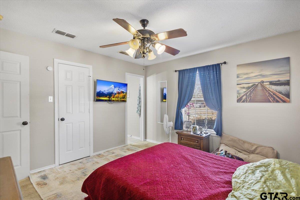 14716 Fox Ridge Tyler, TX 75709 - Photo 14 of 25 a bedroom with a bed and a chandelier