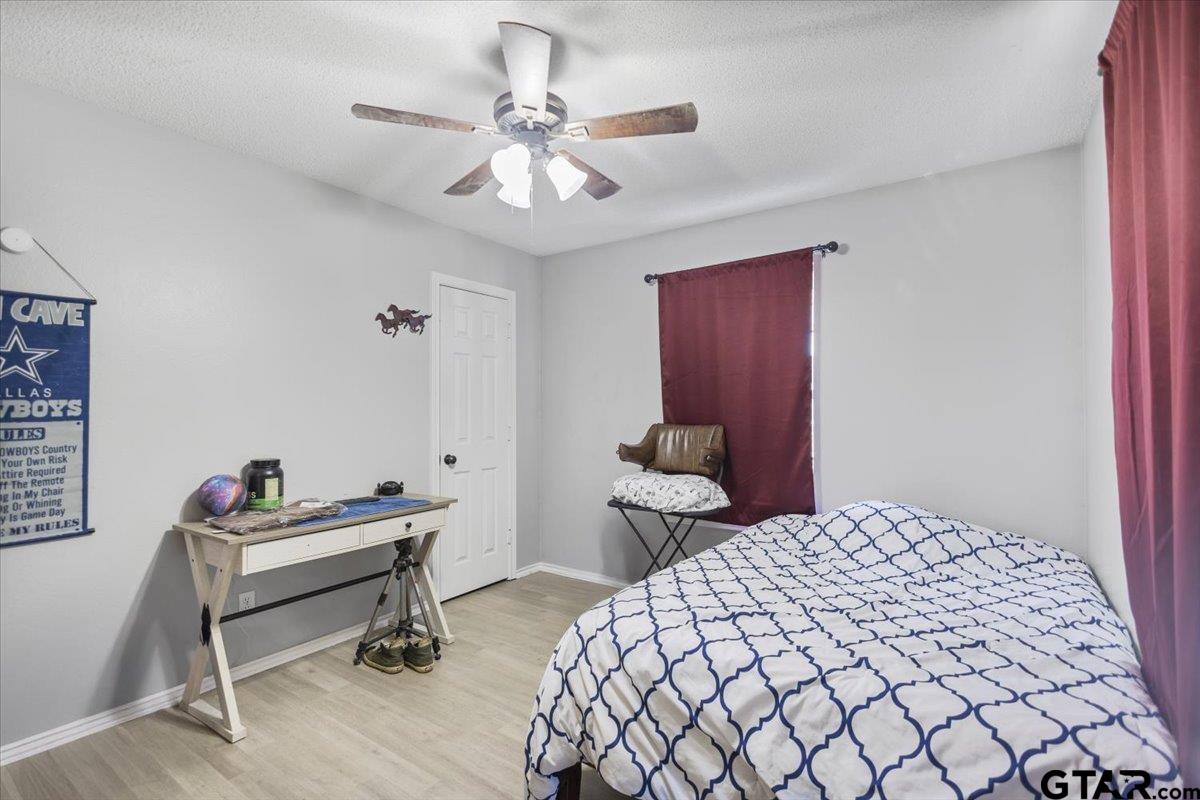 14716 Fox Ridge Tyler, TX 75709 - Photo 18 of 25 a bedroom with a bed and a chandelier