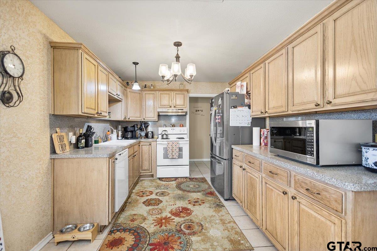 14716 Fox Ridge Tyler, TX 75709 - Photo 10 of 25 a kitchen with stainless steel appliances granite countertop a refrigerator oven a sink dishwasher and white cabinets with wooden floor