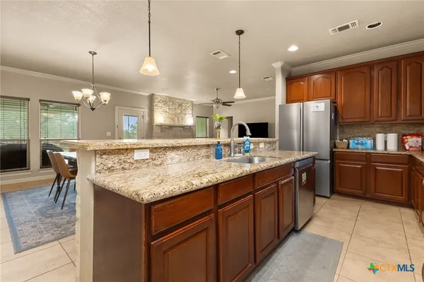 a kitchen with kitchen island a counter top space appliances and a center island