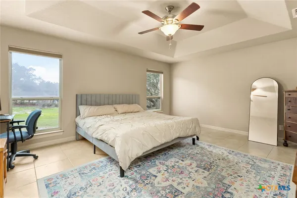 a bedroom with a bed a chandelier and a piano