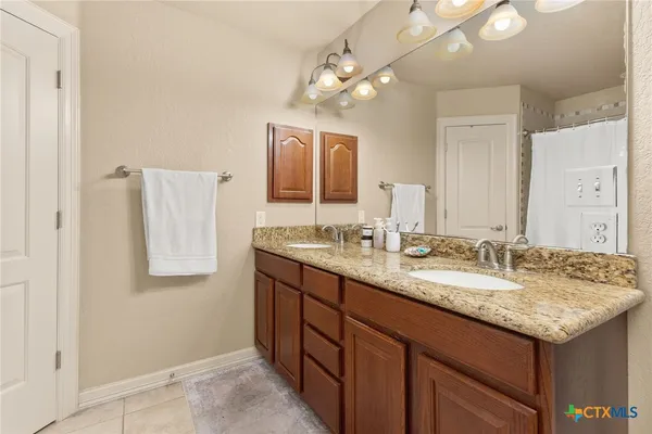 a bathroom with a granite countertop sink and a mirror