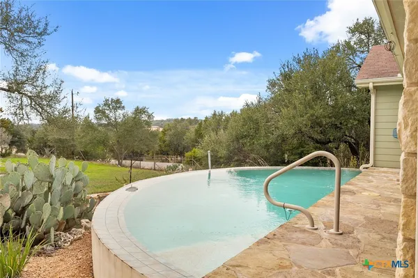 a swimming pool with view of lake in the background