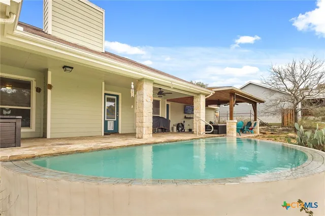a view of a house with a backyard porch and sitting area