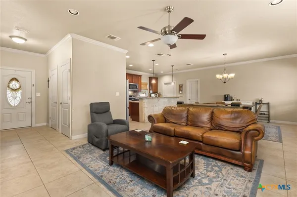 a living room with furniture and a view of kitchen