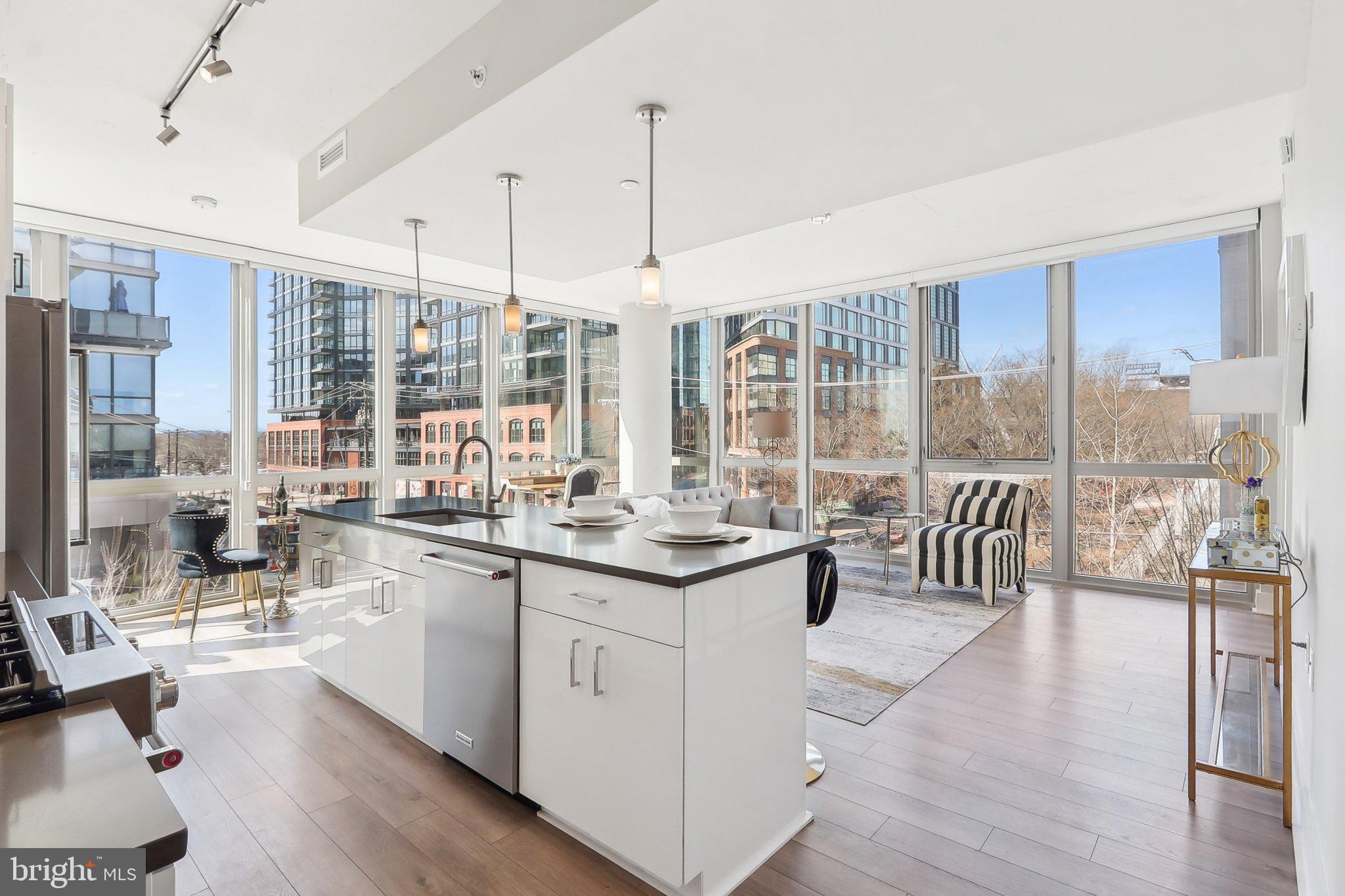 a open kitchen with granite countertop a large window and white cabinets