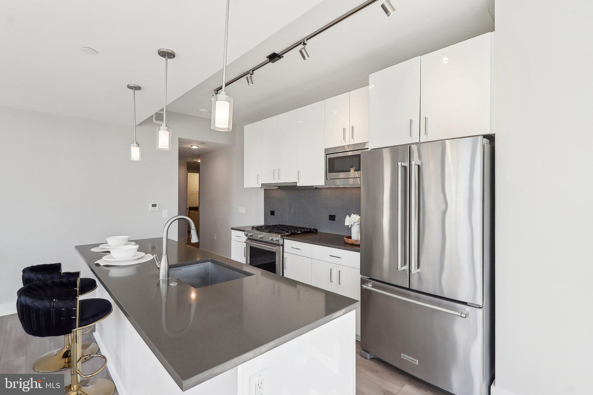 88 V Street Southwest, Unit 311 Washington, DC 20024 - Photo 11 of 32 a kitchen with stainless steel appliances granite countertop a refrigerator a sink a stove and a refrigerator