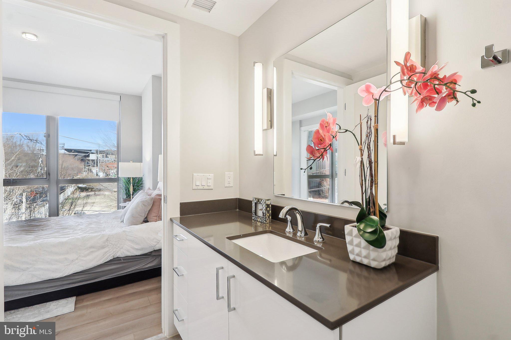 88 V Street Southwest, Unit 311 Washington, DC 20024 - Photo 25 of 32 a en suite bathroom with a granite countertop sink a mirror and a shower