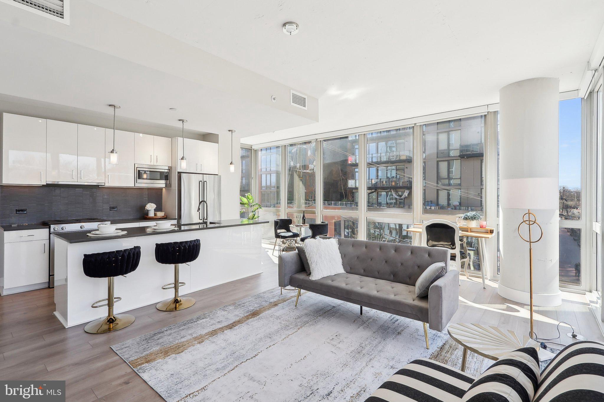 88 V Street Southwest, Unit 311 Washington, DC 20024 - Photo 3 of 32 a living room with furniture and a large window with kitchen view