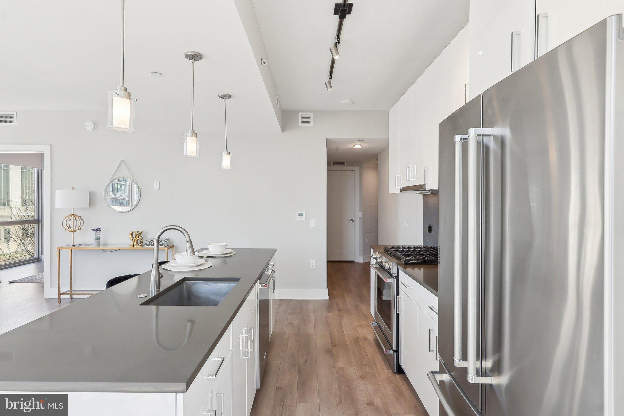 88 V Street Southwest, Unit 311 Washington, DC 20024 - Photo 9 of 32 a kitchen with kitchen island a sink stove and refrigerator