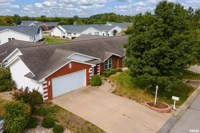 an aerial view of a house with a garden and lake view