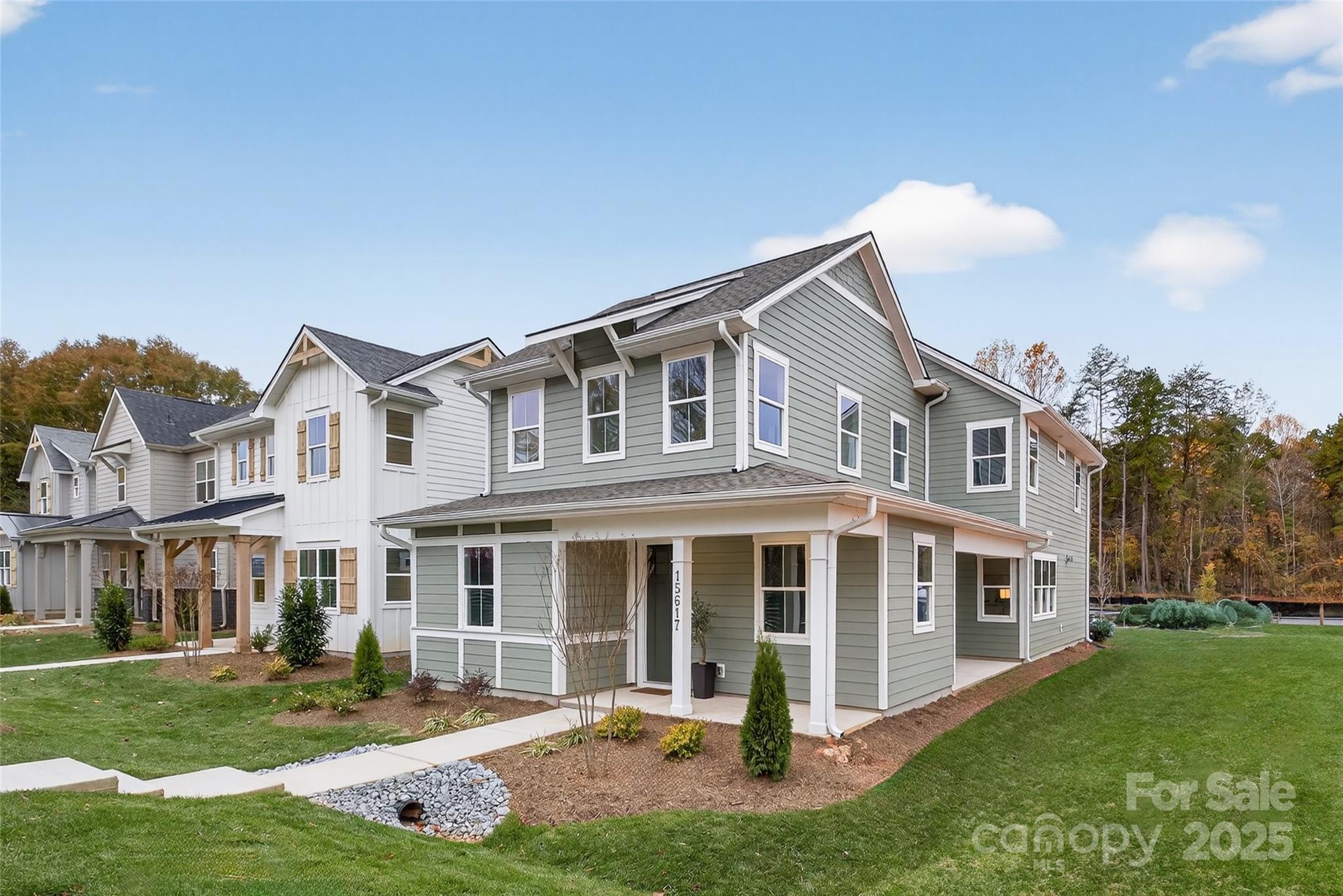 a front view of a house with a yard and trees