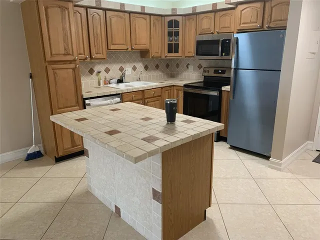 a kitchen with stainless steel appliances granite countertop a refrigerator sink stove and microwave