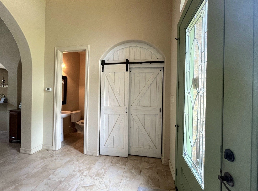 27585 Rio Blanco Drive Splendora, TX 77372 - Photo 7 of 39 Once stepping into the foyer, the formal dining room is behind the barn door. As you can see, the half bath is located in this area.