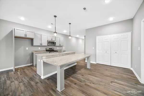 a kitchen with kitchen island a wooden floor and white appliances