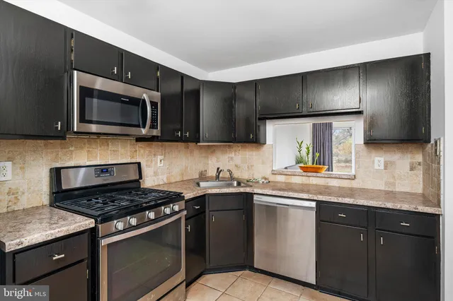 a kitchen with stainless steel appliances a sink stove and microwave