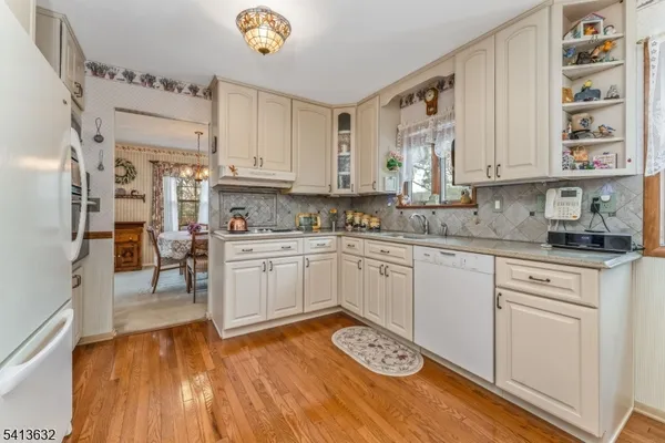 a kitchen with a refrigerator and white cabinets