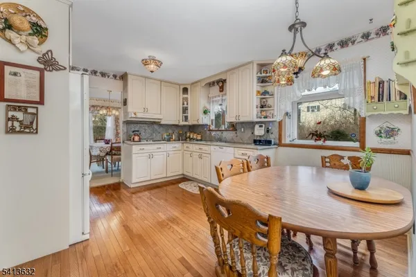 a large kitchen with stainless steel appliances granite countertop a stove a sink dishwasher and a refrigerator with wooden floor