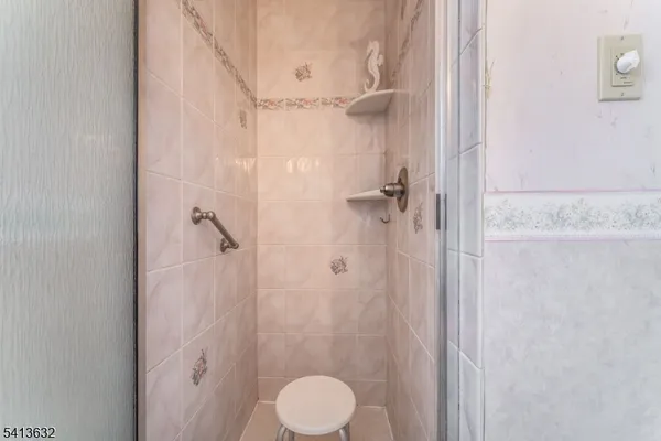 a bathroom with a granite countertop shower sink vanity and a toilet