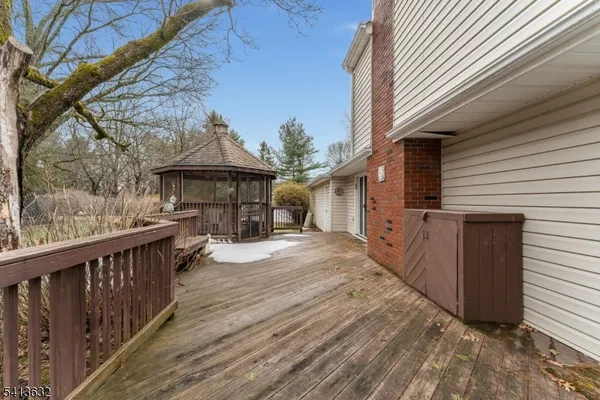 a front view of house with wooden deck and a basket ball court