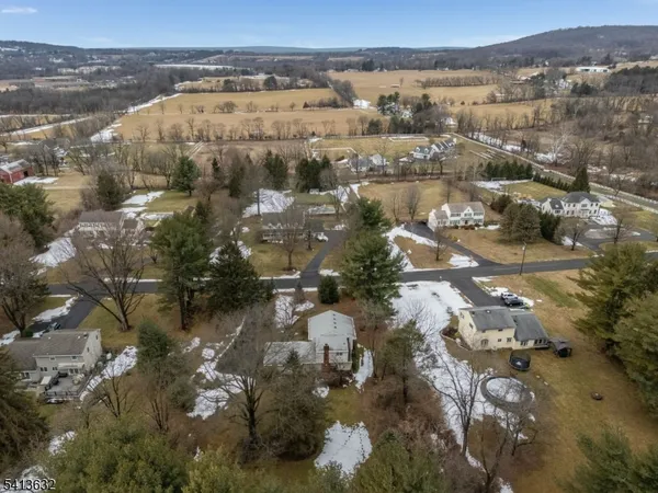 an aerial view of house with yard and mountain view in back
