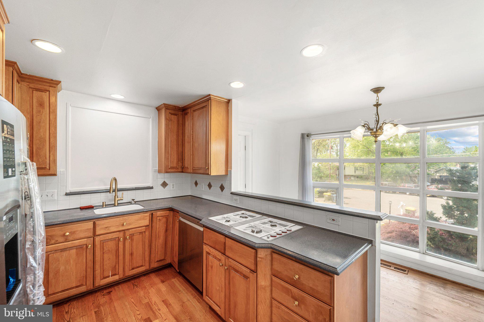 6423 Cabell Court Springfield, VA 22150 - Photo 11 of 58 a kitchen with a sink stove and wooden cabinets