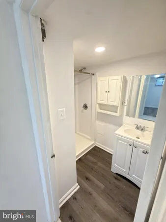 a hallway view with wooden floor and cabinets