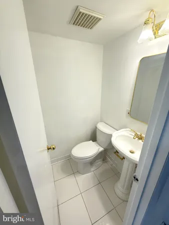 a white toilet sitting next to a white sink and vanity