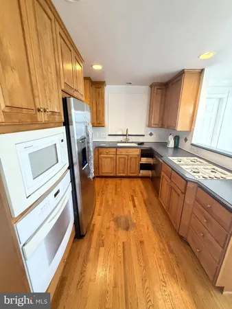 a kitchen with a sink a wooden floor and a counter top space