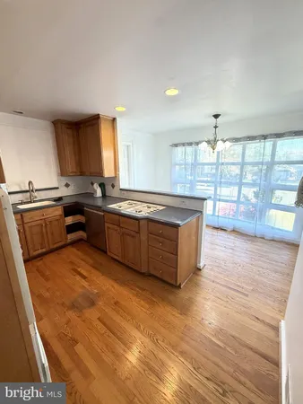 a large kitchen with wooden floors and stainless steel appliances
