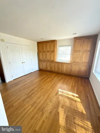 a view of a room with wooden floor and white walls