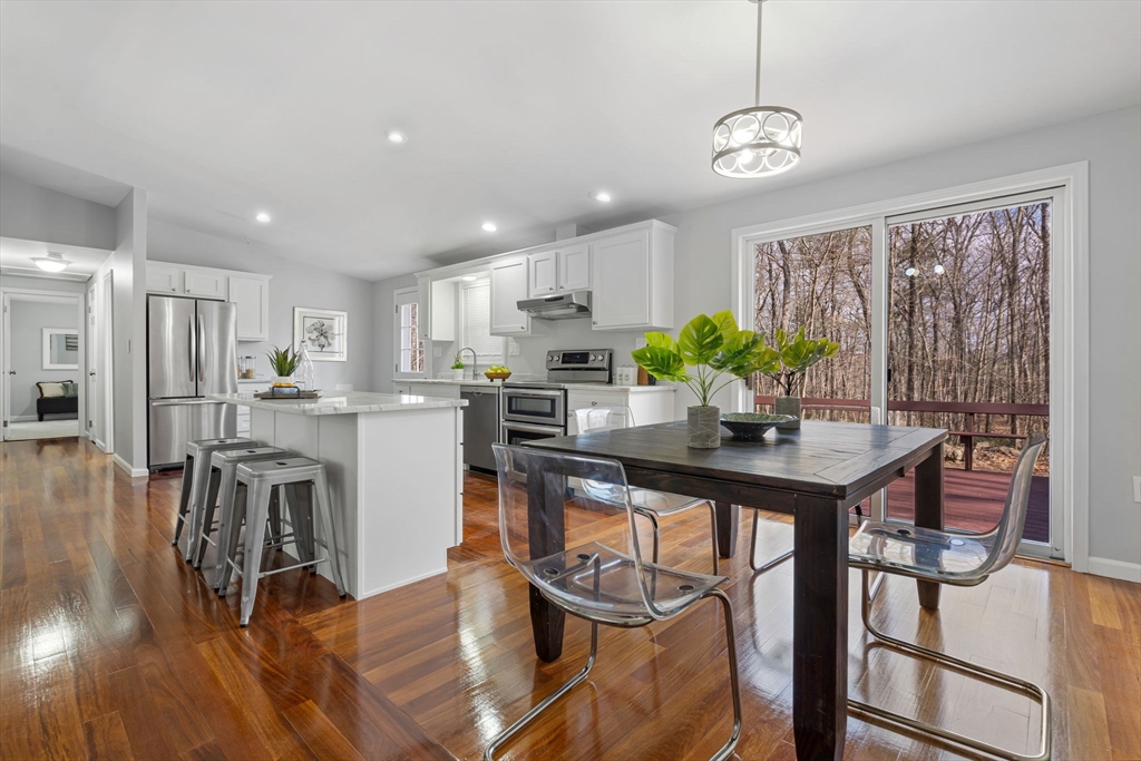 41 Casey Road Spencer, MA 01562 - Photo 11 of 39 a kitchen with stainless steel appliances granite countertop a dining table chairs stove and white cabinets