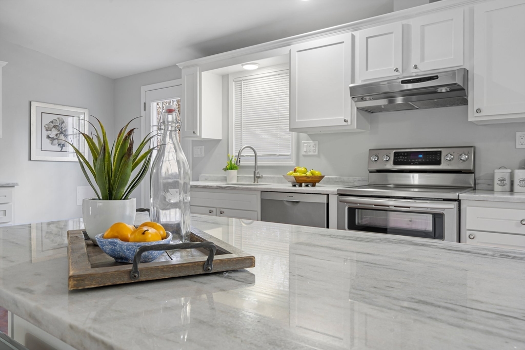 41 Casey Road Spencer, MA 01562 - Photo 7 of 39 a kitchen with stainless steel appliances a stove a sink cabinets and a wooden floor