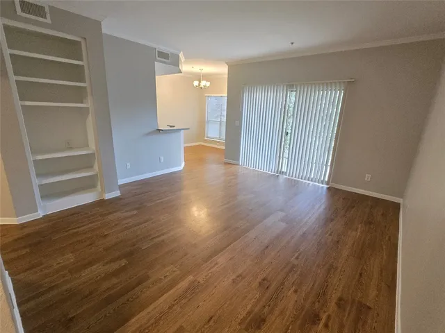 a view of a hallway with wooden floor and entryway