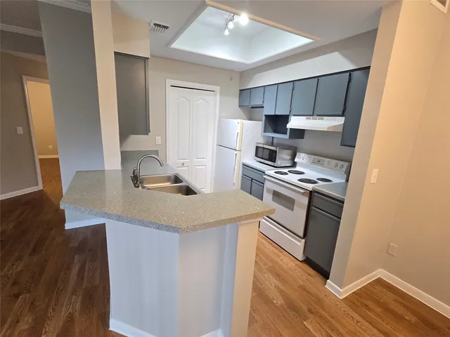 a kitchen with a sink a stove a refrigerator and a window