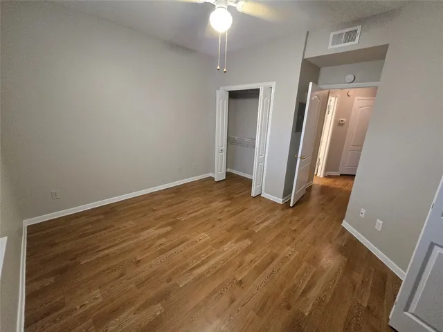 an empty room with wooden floor and closet