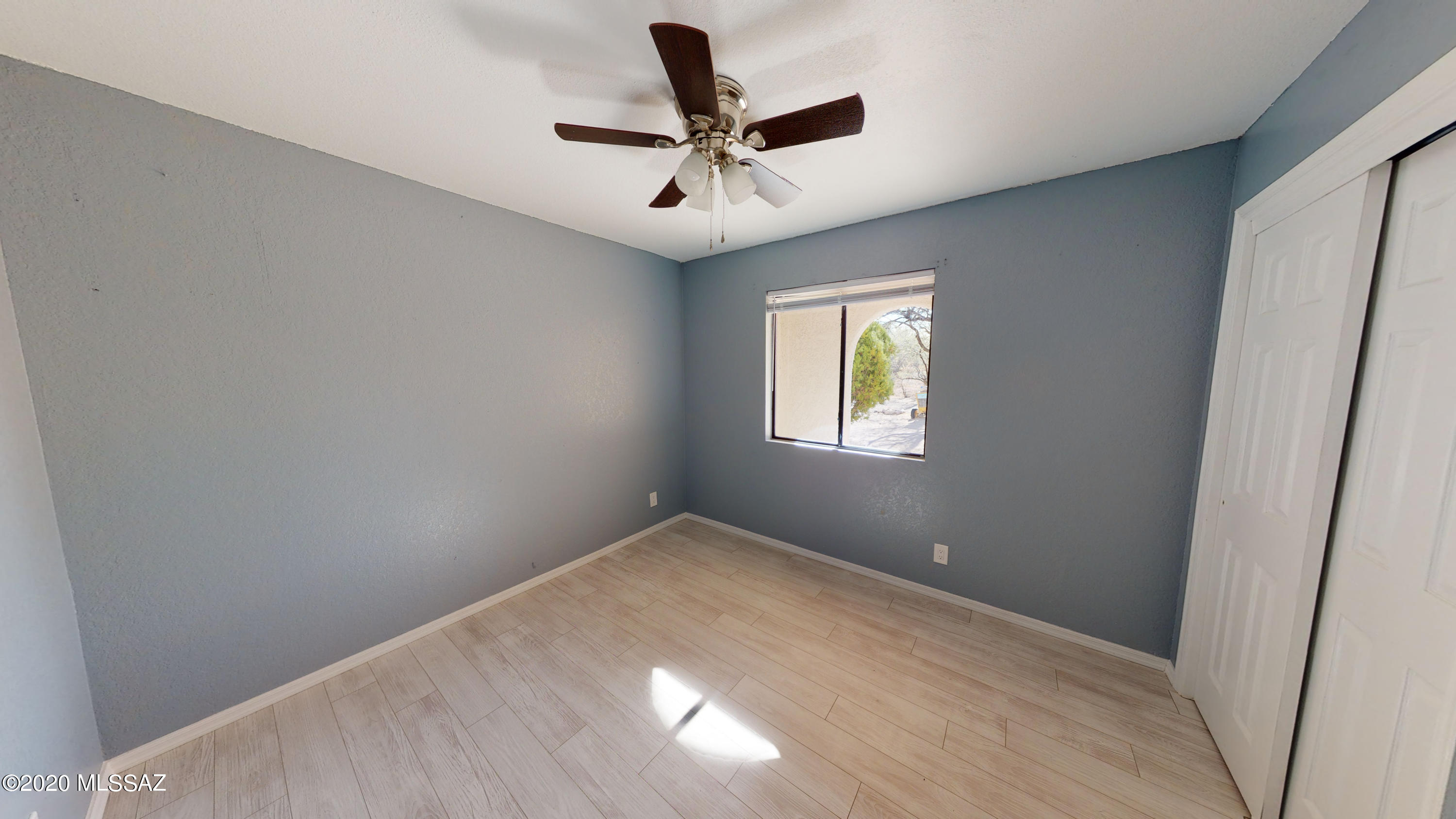 1034 Zorrita Court, Unit CORTE Rio Rico, AZ 85648 - Photo 9 of 16 an empty room with a window and a ceiling fan
