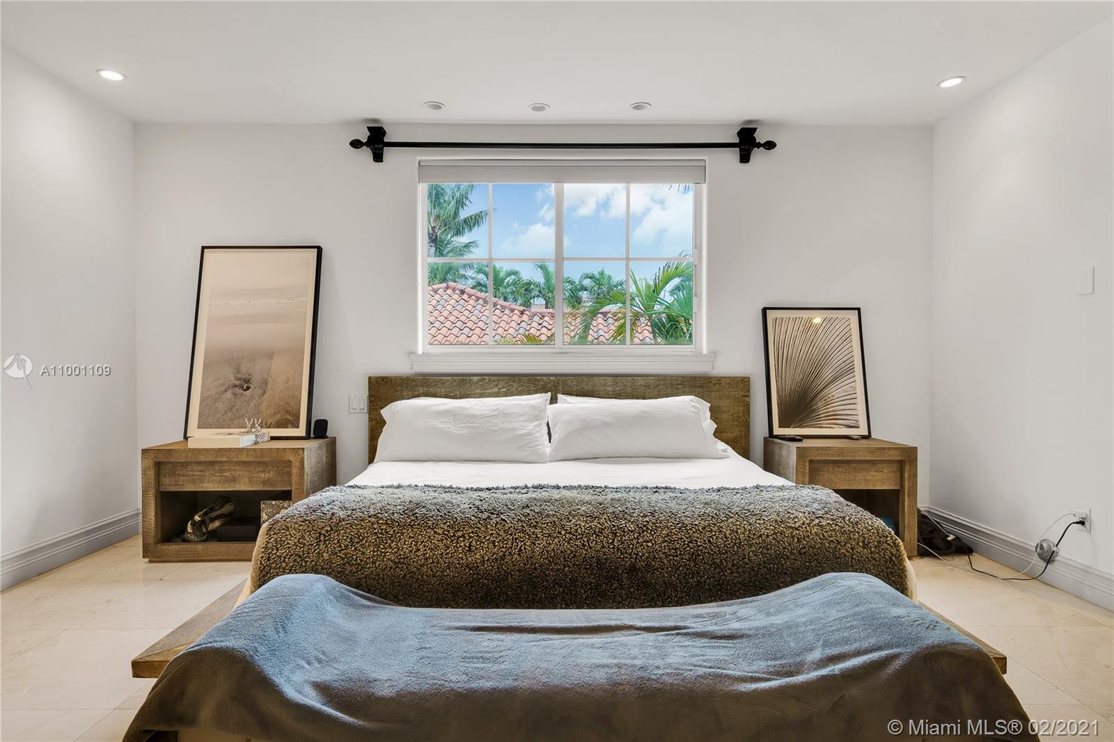 570 Hampton Lane Key Biscayne, FL 33149 - Photo 21 of 60 a large bed sitting in a bedroom next to a window