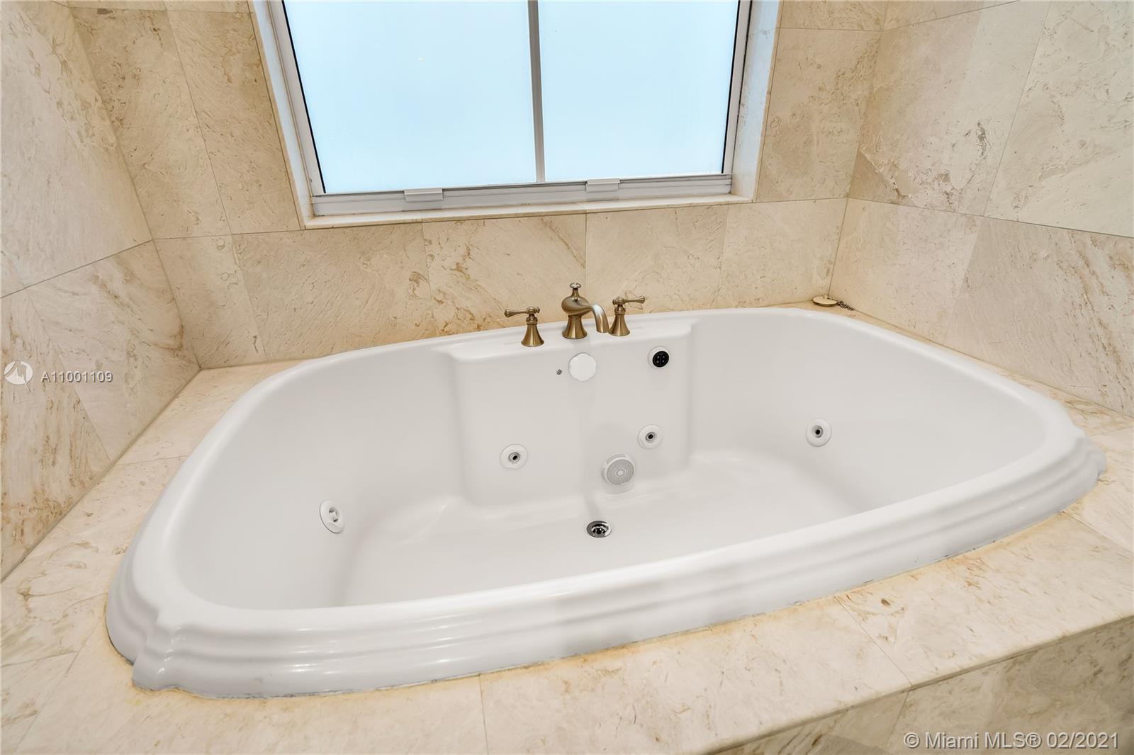 570 Hampton Lane Key Biscayne, FL 33149 - Photo 28 of 60 a white bath tub sitting in a bathroom