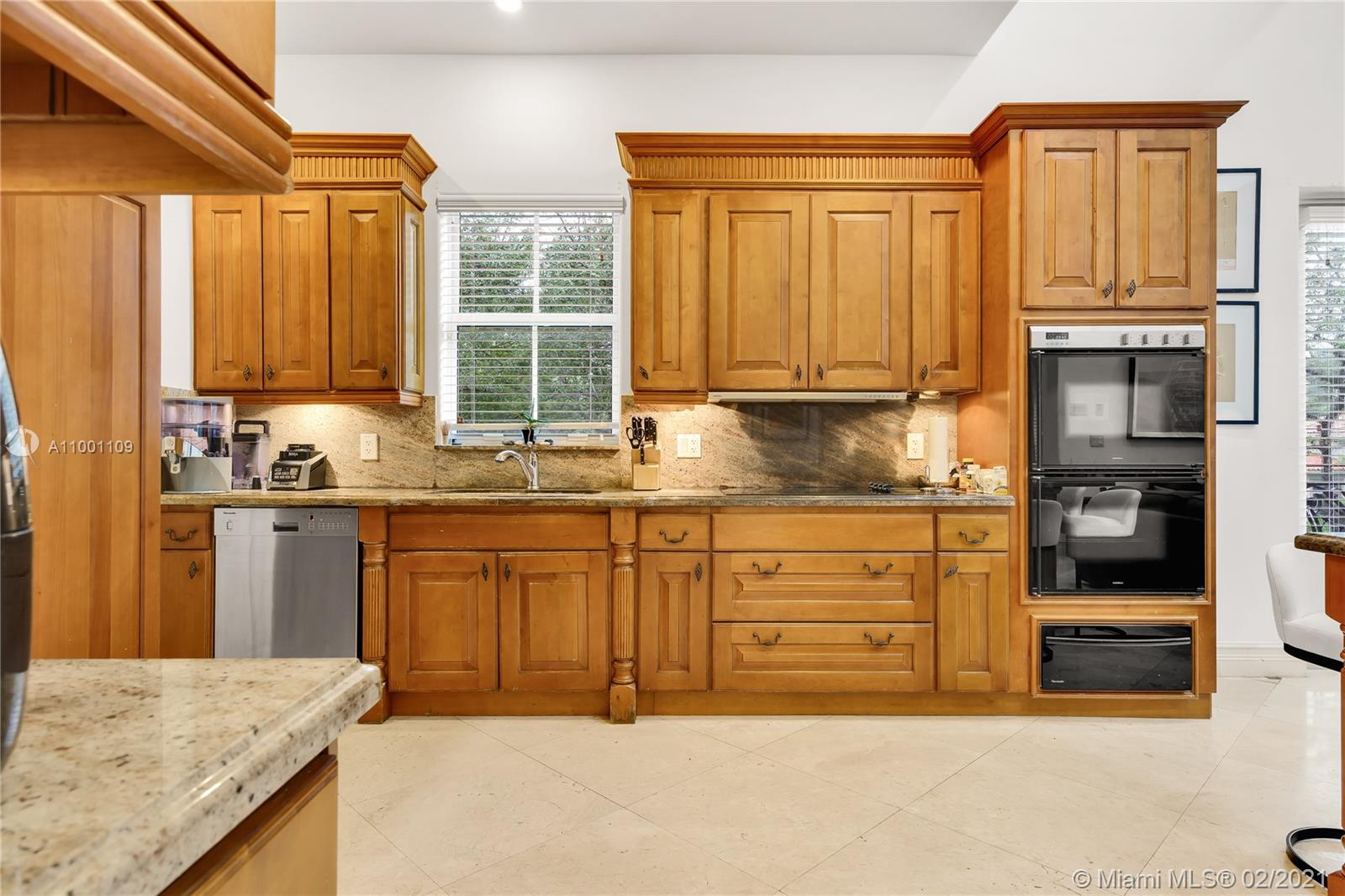 570 Hampton Lane Key Biscayne, FL 33149 - Photo 38 of 60 a kitchen with stainless steel appliances granite countertop a refrigerator a stove top oven and a sink with large window