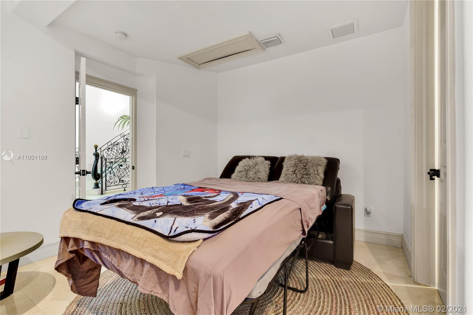 570 Hampton Lane Key Biscayne, FL 33149 - Photo 39 of 60 a bedroom with a bed and a table in it