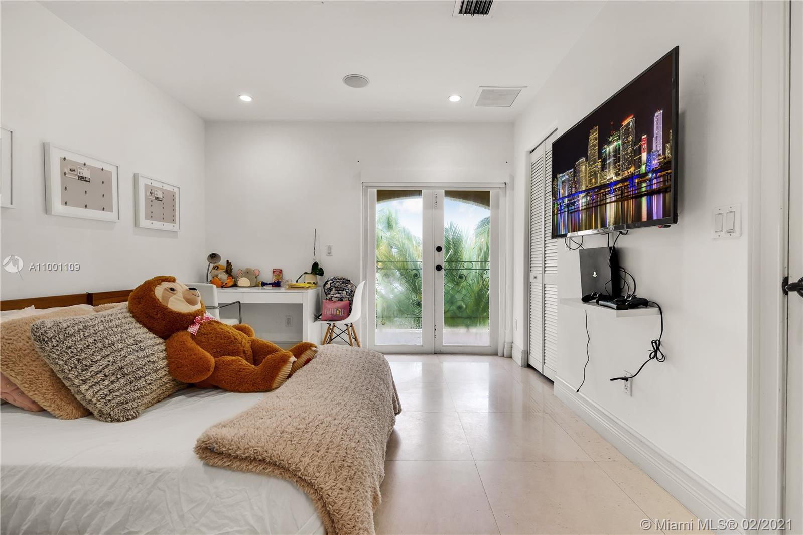 570 Hampton Lane Key Biscayne, FL 33149 - Photo 49 of 60 a bedroom with furniture and a book shelf