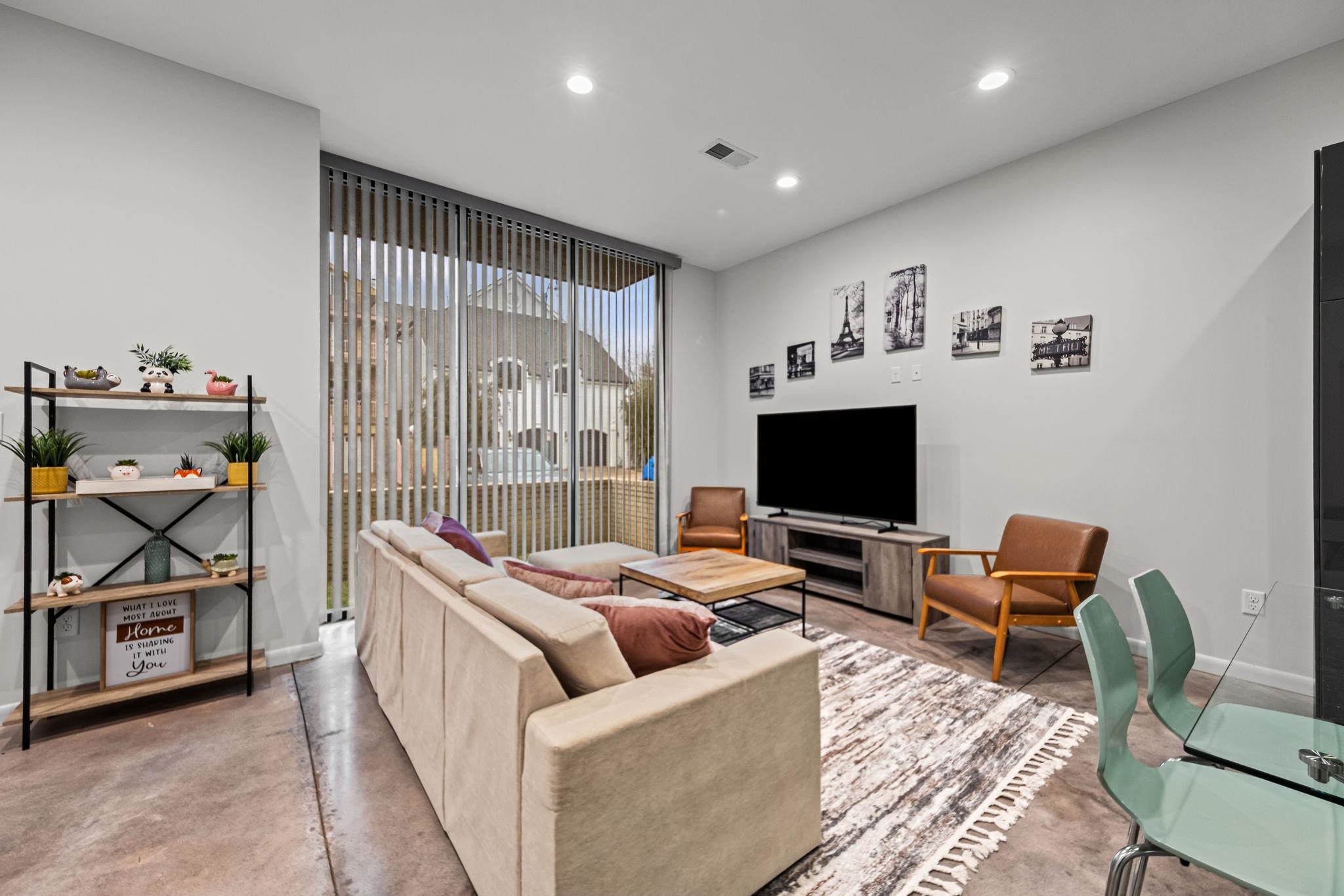 448 Tennessee Street Memphis, TN 38103 - Photo 36 of 39 Spacious living area featuring polished concrete flooring, recessed lighting, and a large sliding glass door with vertical blinds