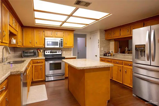 a kitchen with stainless steel appliances granite countertop a sink stove and refrigerator
