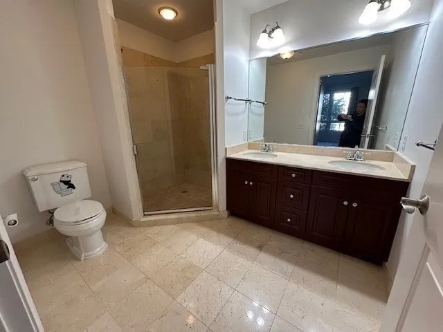 a spacious bathroom with a granite countertop sink toilet and shower