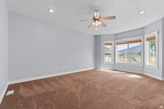1501 West Elk Circle Mapleton, UT 84664 - Photo 22 of 39 Expansive room featuring a bay window with mountain scenery, recessed lighting, and a ceiling fan