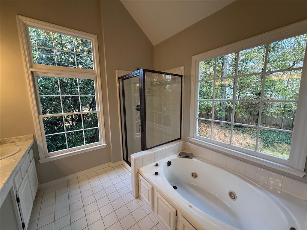 5325 Hillgate Crossing Alpharetta, GA 30005 - Photo 19 of 35 a bathroom with a tub a sink and a large window