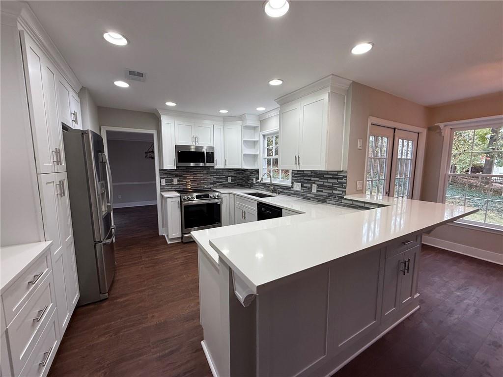 5325 Hillgate Crossing Alpharetta, GA 30005 - Photo 4 of 35 a kitchen with stainless steel appliances a stove a sink a refrigerator and cabinets