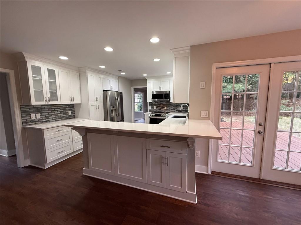 5325 Hillgate Crossing Alpharetta, GA 30005 - Photo 5 of 35 a kitchen with stainless steel appliances granite countertop a stove a sink a refrigerator and white cabinets with wooden floor