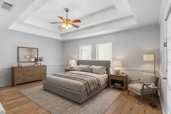 an empty room with wooden floor fan and windows